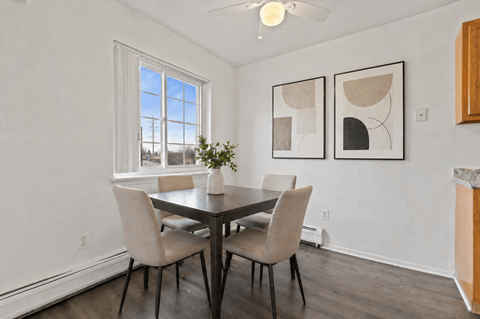 A dining room with a table and chairs.