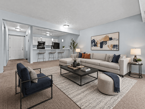 A living room with a white couch, a blue chair, and a coffee table.