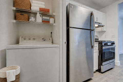 A kitchen with a refrigerator, stove, and oven.