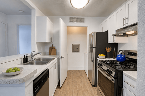 A kitchen with black appliances and white cabinets.