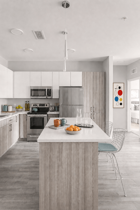 A modern kitchen with a large island and a dining area.