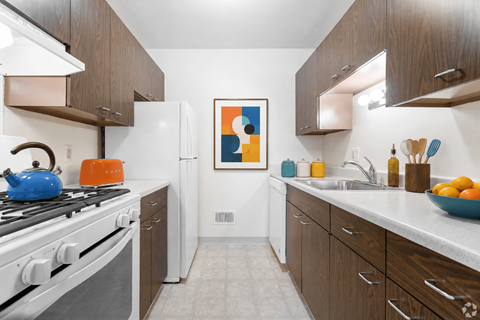 A modern kitchen with white appliances and wooden cabinets.
