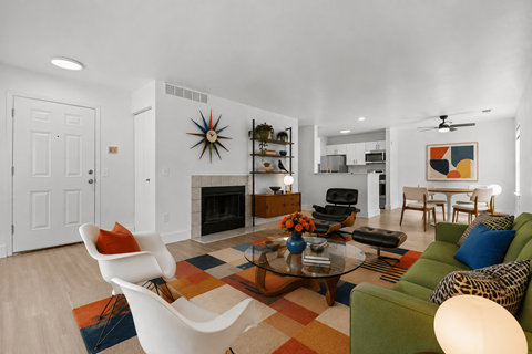 A living room with a leopard print couch and a white chair.