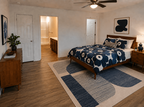 A bedroom with a bed, a ceiling fan, and a rug.