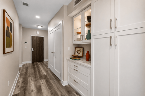 A hallway with a brown floor and white walls.