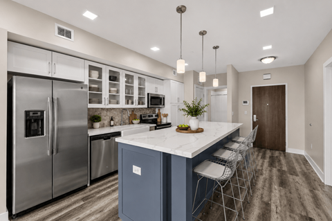 A modern kitchen with a large island and stainless steel appliances.