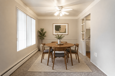 A dining room with a table and chairs.