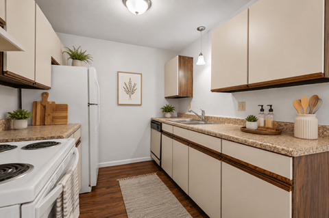 A kitchen with white appliances and wooden cabinets.