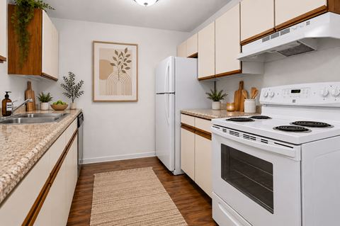 A kitchen with a white stove top oven and a white refrigerator.