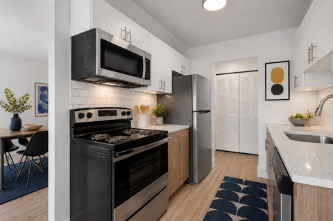 A modern kitchen with a black stove top oven and a black microwave above it.