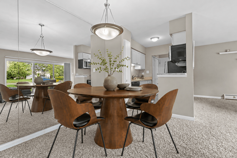 A modern dining room with a round table and chairs.