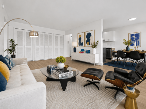 A living room with a white couch, a coffee table, and a dining table with chairs.