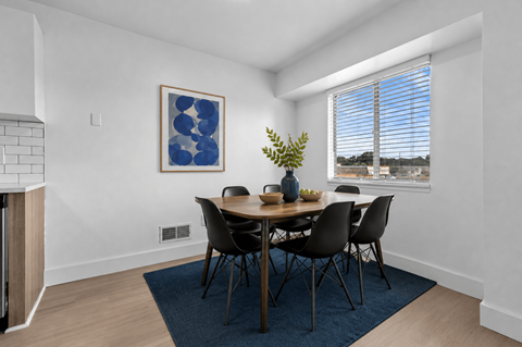 A dining room with a table set for four.