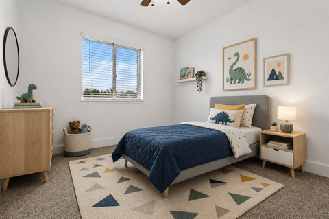 A bedroom with a blue bedspread and a rug with triangles on it.
