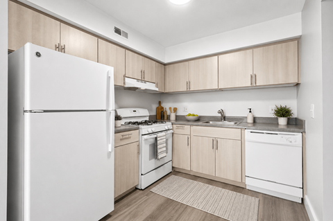 A kitchen with white appliances and wooden cabinets.