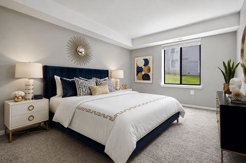 A bedroom with a large bed and a mirror on the wall.
