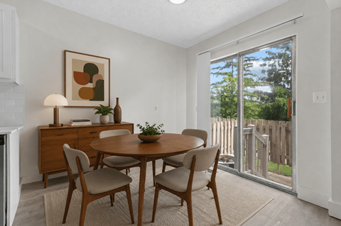 A dining room with a wooden table and chairs.