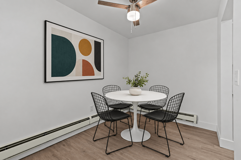 A dining room with a white table and chairs.