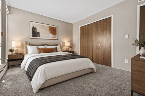A bedroom with a large bed and a painting above it.
