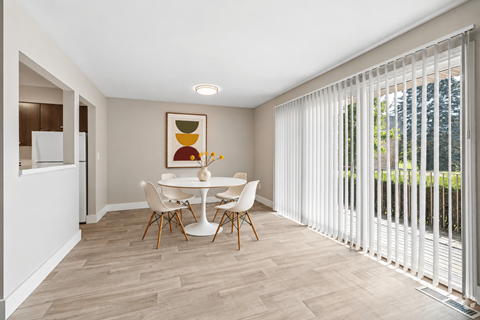 A dining room with a white table and chairs.