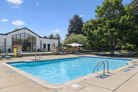 A large outdoor swimming pool with a building in the background.