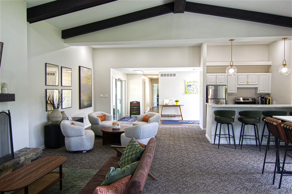 Clubroom with a couch, chairs, and a fireplace.