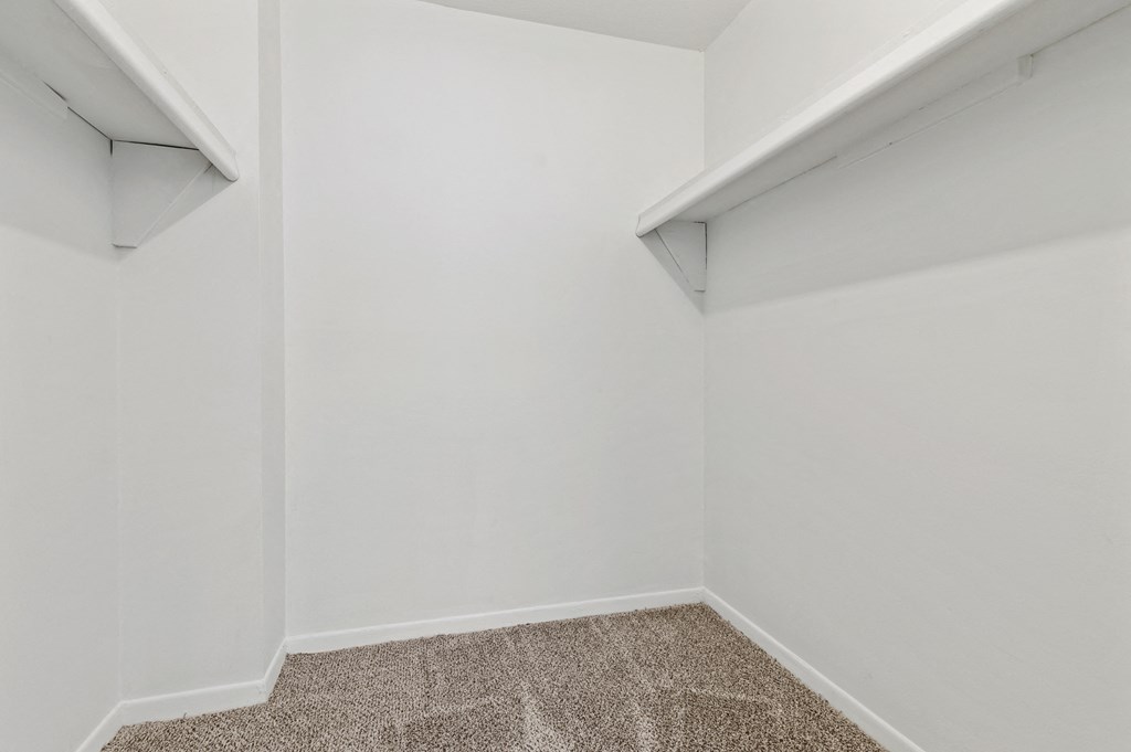 an empty room with white walls and a carpeted floor