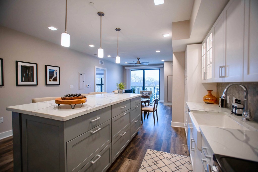 a large kitchen with white counter tops and a dining area