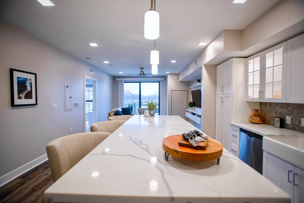 a white kitchen with a large island in the middle