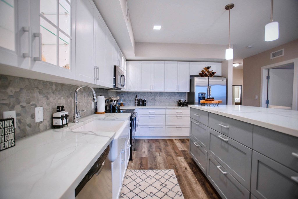 a large kitchen with white counter tops and white cabinets