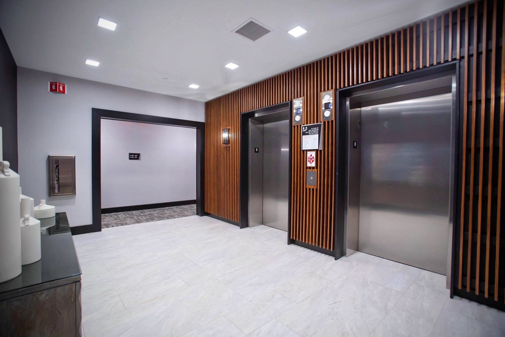 the elevators in the lobby of a building with stainless steel doors