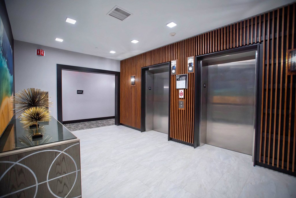 the elevators in the lobby of a building with metal doors