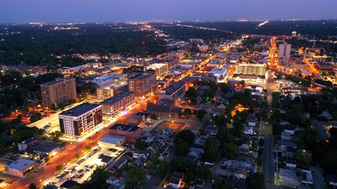 A cityscape at night with buildings and streets illuminated.