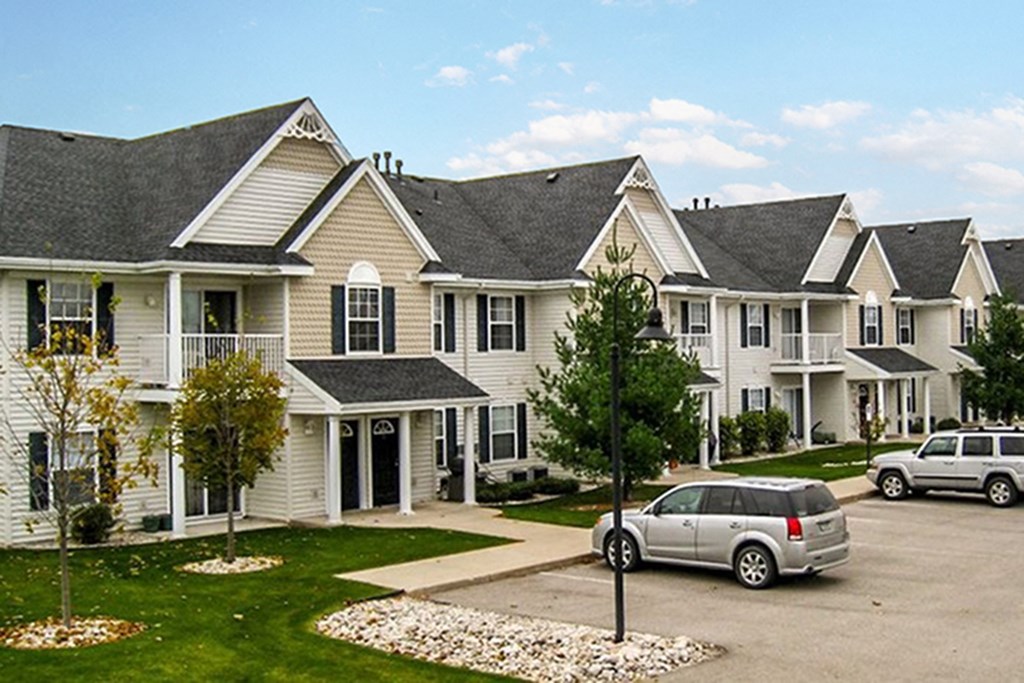 a row of houses with cars parked in front of them