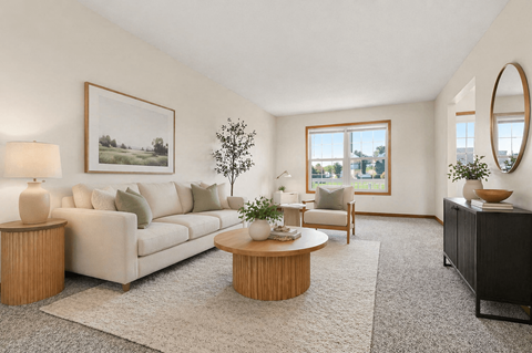 A living room with a couch, a coffee table, and a painting on the wall.