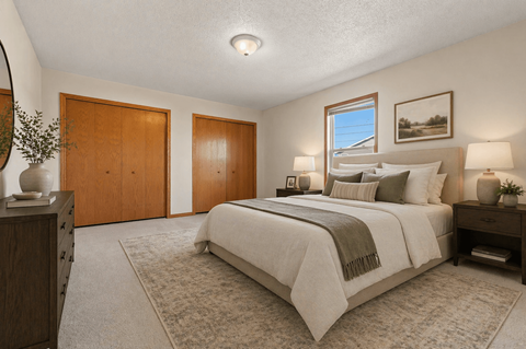 A bedroom with a large bed and a window.