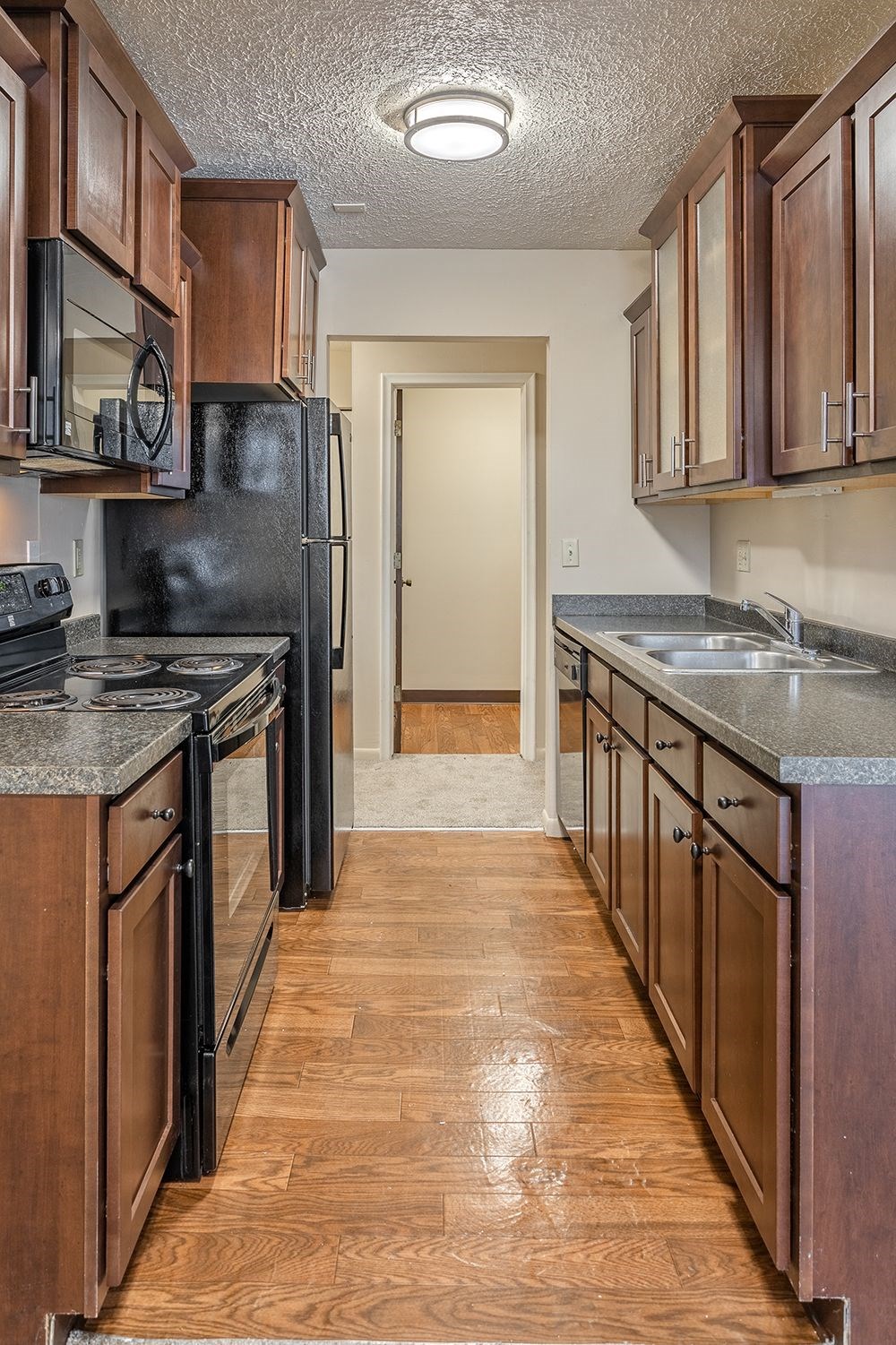 a kitchen with wooden cabinets and black appliances