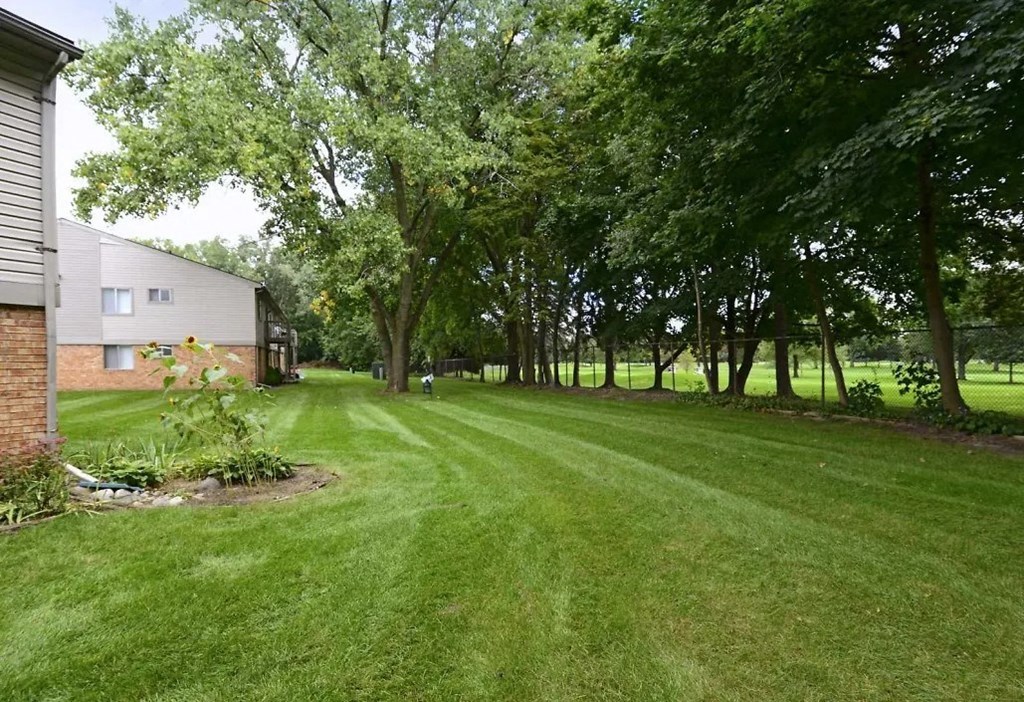 a large yard with a house and trees
