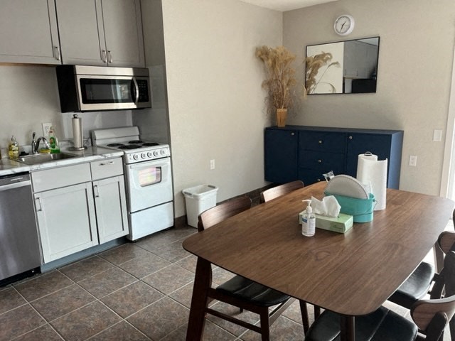a kitchen with white appliances and a wooden table