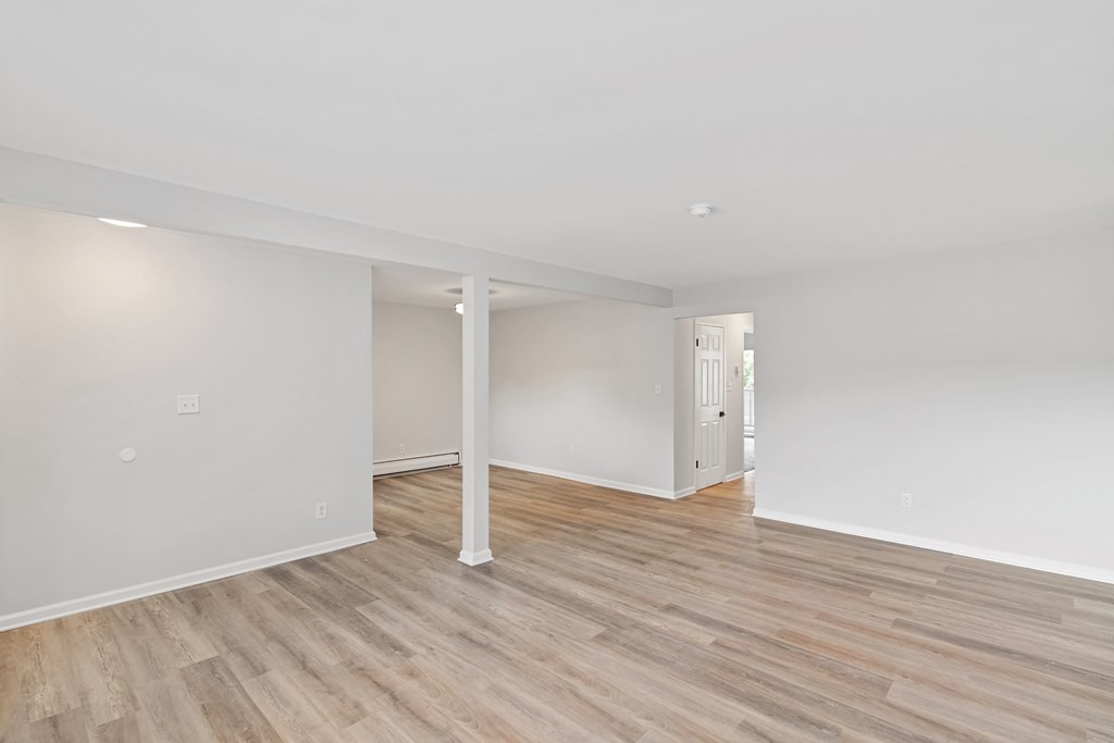 A room with wooden flooring and white walls.