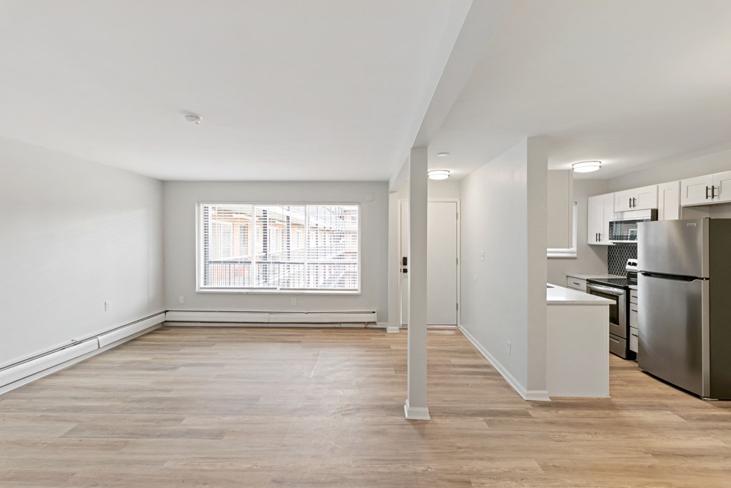 A kitchen area with a refrigerator, sink, and cabinets.