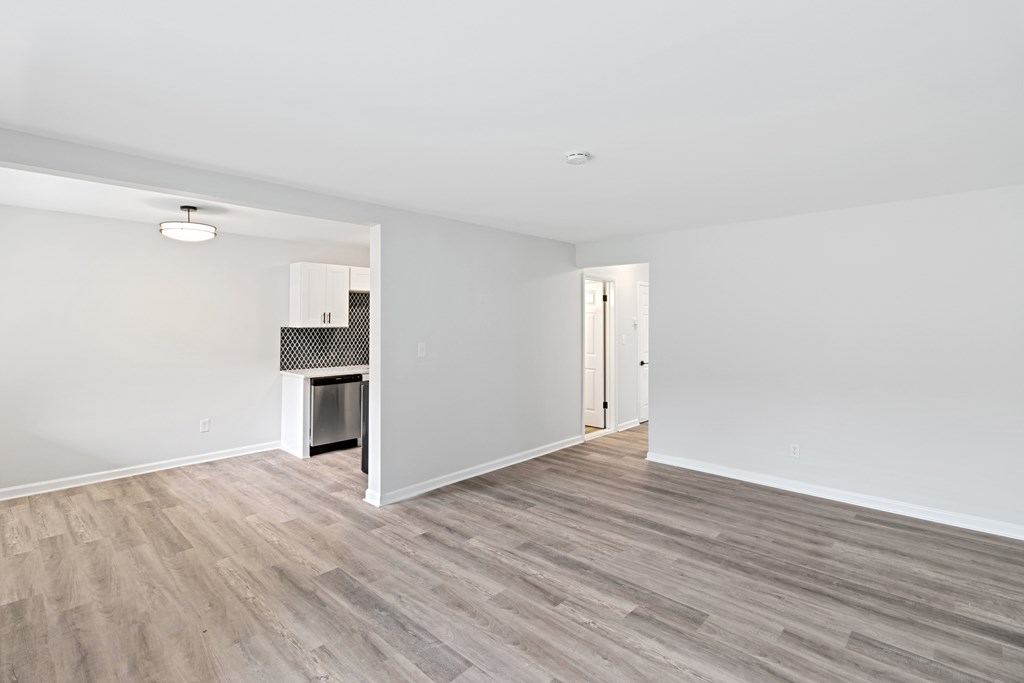 A room with a wood floor and a doorway leading to another room.