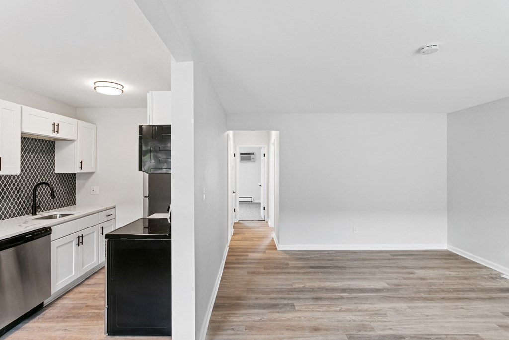 A kitchen with black countertops and stainless steel appliances.