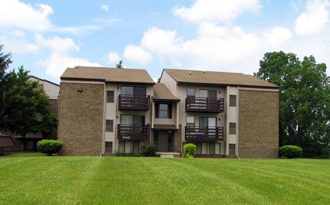 an apartment building with balconies on a green lawn