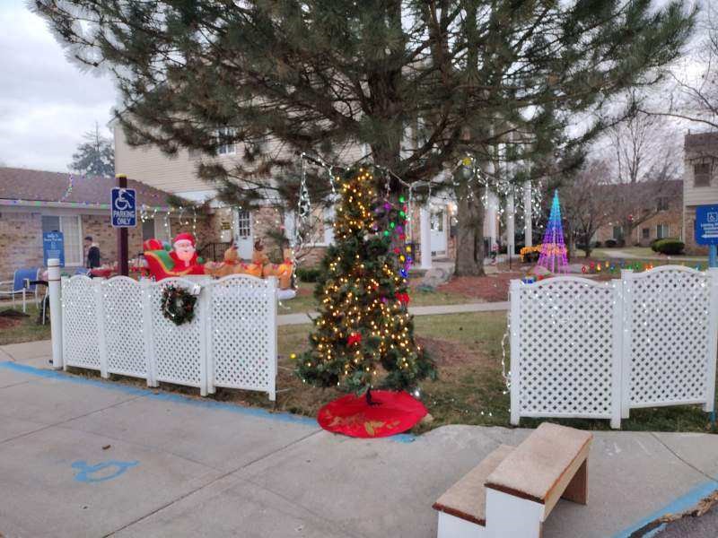a christmas tree in front of a white fence