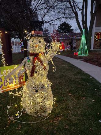 a snowman covered in christmas lights on a lawn