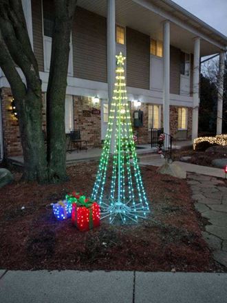 a christmas tree is lit up in front of a house