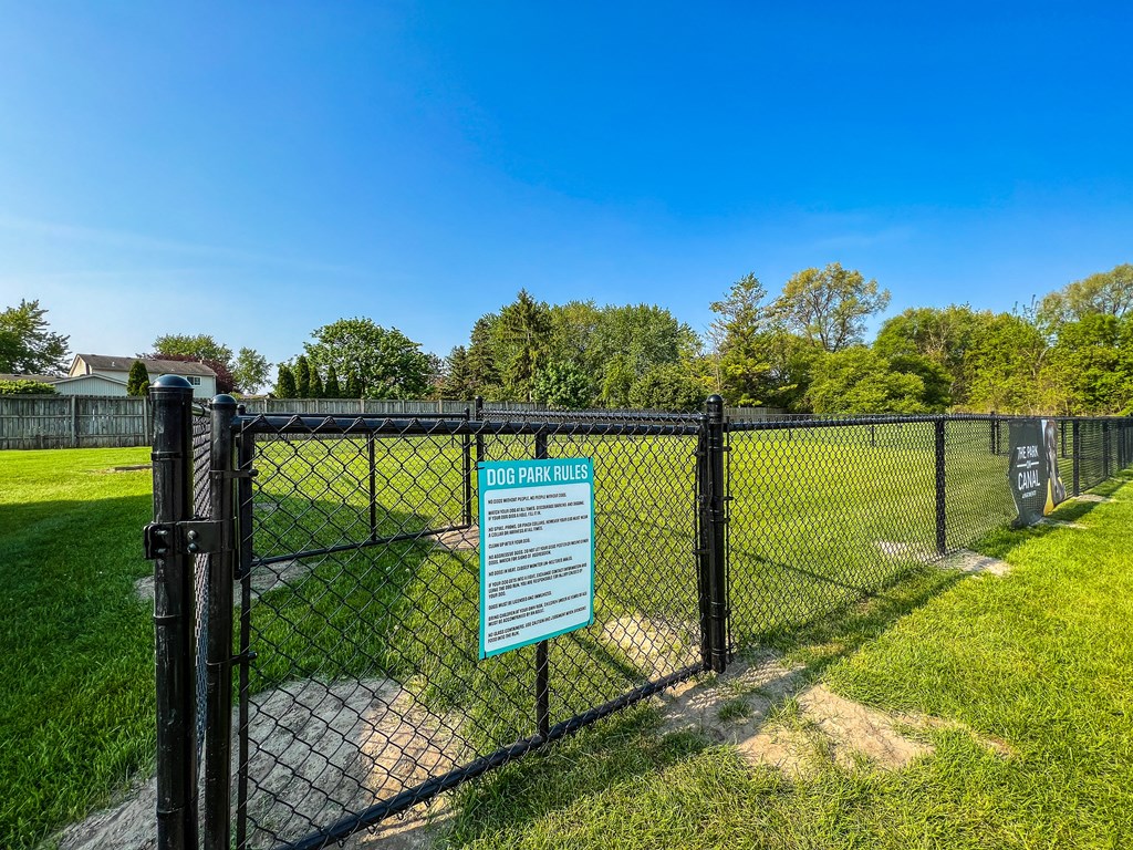 a dog park with a black chain link fence and a sign that says dog park closed  at Park On Canal Apartments, Clinton Twp, MI