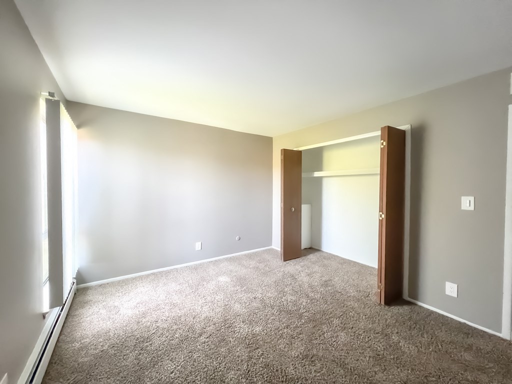 a bedroom with a carpeted floor and an open door