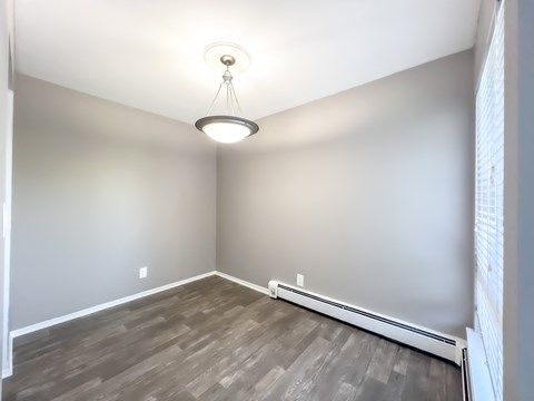 an empty room with hardwood floors and a light fixture
